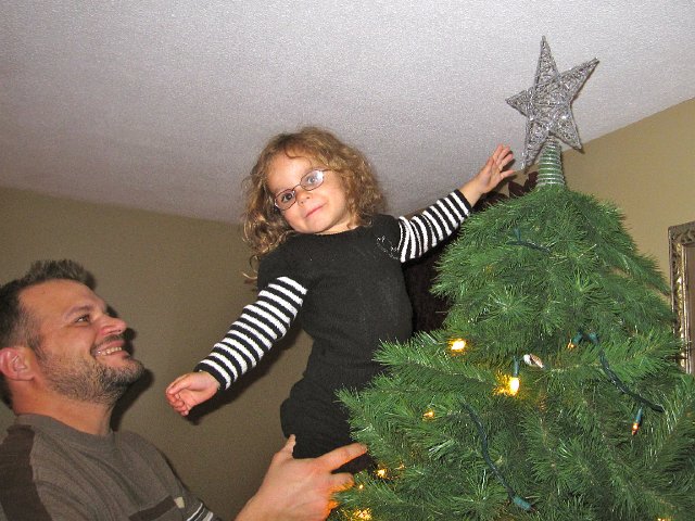 IMG_7423.jpg - Our little star is helping Daddy put the tree topper in place.