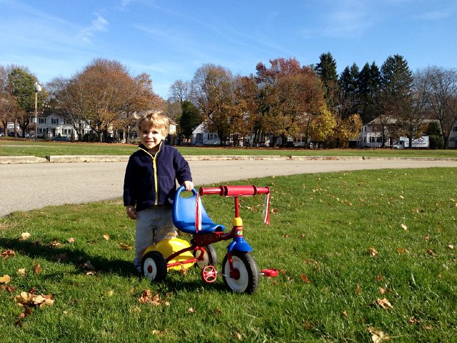 IMG_2690.jpg - As Catherine did her loops around the park on her bicycle, Nathan was fascinated with the lawn care guys.  He pretended that with his storage bucket down on the back of his tricycle, he also was cutting the grass.