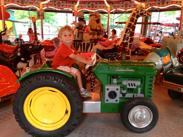IMG_3913.jpg - Luckily a ride on a tractor helped him forget about the rollercoaster for a little bit.