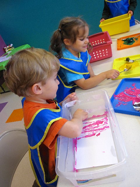 IMG_5876.jpg - Messy art includes:  paint, marbles, a spoon and paper.
