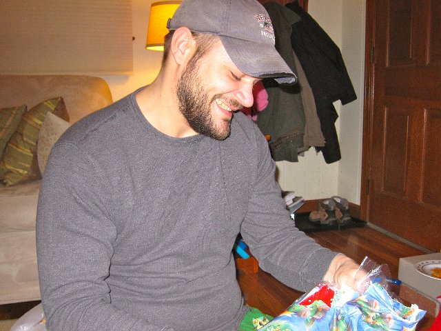 IMG_7596.jpg - Michael chuckling while opening his stocking stuffer (red solo cups).