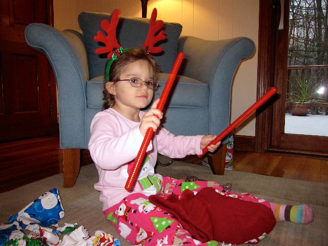 IMG_3351.jpg - It's always fun when Santa adds to our musical instrument collection.  Catherine with her wooden rhythm sticks.