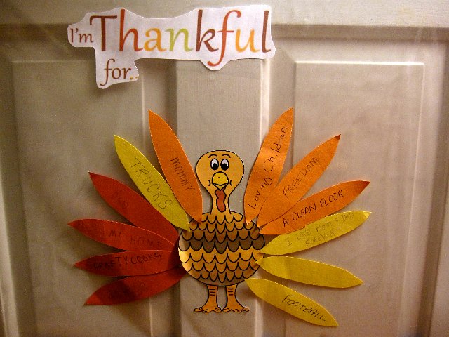 IMG_8862.jpg - Our "What are You Thankful for" project.  Each of us contributed a few feathers for make this pretty grateful bird.  (Catherine: School, Crafty Cooks, My Home, Dad.  Nathan: Football, Trucks, a scribble, I Love Mom & Dad Forever.  Dad: Loving Children, Mommy.  Mom:  Freedom, A Clean Floor.)